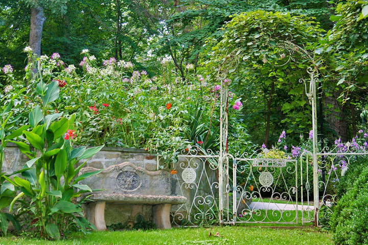 Bank neben Pflanzbogen in einem bewachsenen Bauerngarten