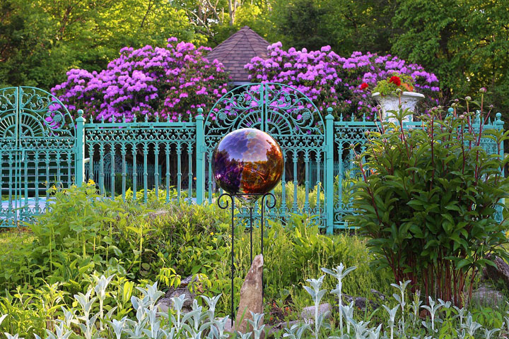 Glaskugel und Zaun in einem verwachsenen Garten